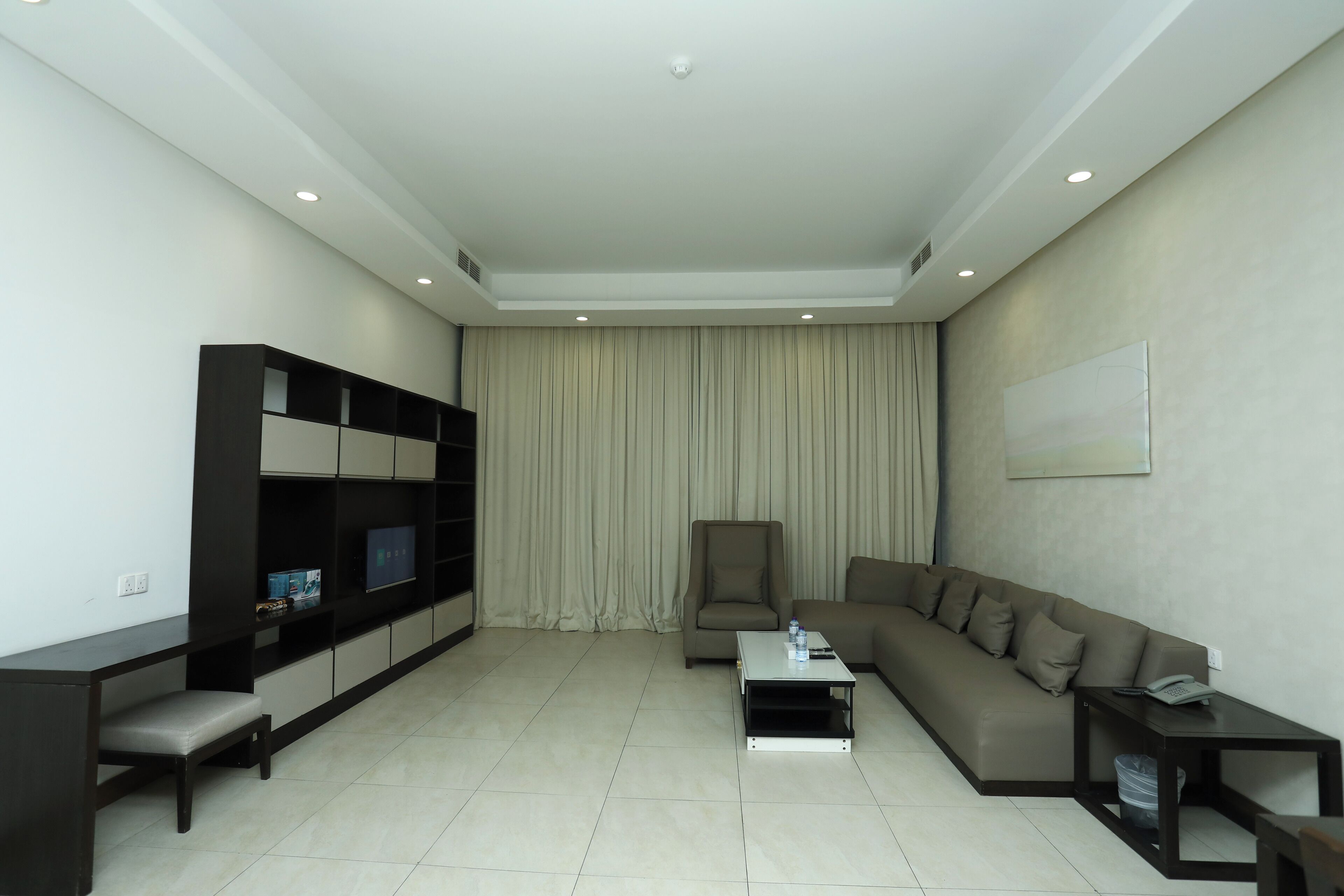 A modern living room with a sofa, a coffee table, a TV stand, and a chair.