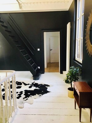 A staircase leading to a room with a cowhide rug, a wooden bench, and a potted plant. - Maison Mercy - Domaine Avec 2 Maisons - 17 Couchages sur les Côtes de Bourg (Saint-Gervais)