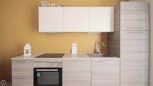 Una cocina moderna con horno empotrado, un lavamanos y un armario sobre la encimera.