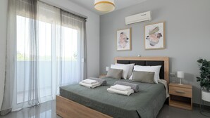 Un dormitorio moderno con una cama grande, mesitas de noche y una obra de arte en la pared.