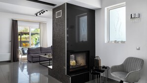 Una sala de estar moderna con chimenea, un sofá, una mesa de centro y un sillón.