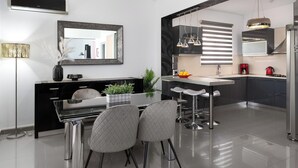 Una cocina moderna con comedor, electrodomésticos de acero inoxidable y un espejo grande.