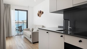 Una cuina moderna amb armaris blancs, un taulell negre i una campana extractora d'acer inoxidable.
