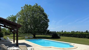 A swimming pool with lounge chairs and a pergola. - Stylish barn conversion  with a beautiful pool and stunning 4ha grounds. (Moustier)
