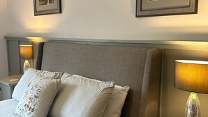 A neatly arranged hotel room with a large bed, two bedside lamps, and two framed pictures on the wall. - Stylish barn conversion  with a beautiful pool and stunning 4ha grounds. (Moustier)