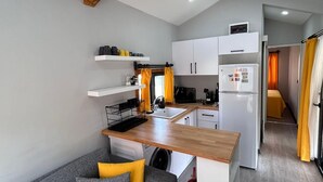 A compact kitchenette with a built-in oven, a sink, and a refrigerator. - Era House (Marmaris)