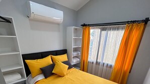 A bedroom with a bed, a wardrobe, a shelf unit, and an air conditioning unit. - Era House (Marmaris)