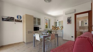 Una cocina moderna con comedor, un sofá rojo y un amplio ventanal.