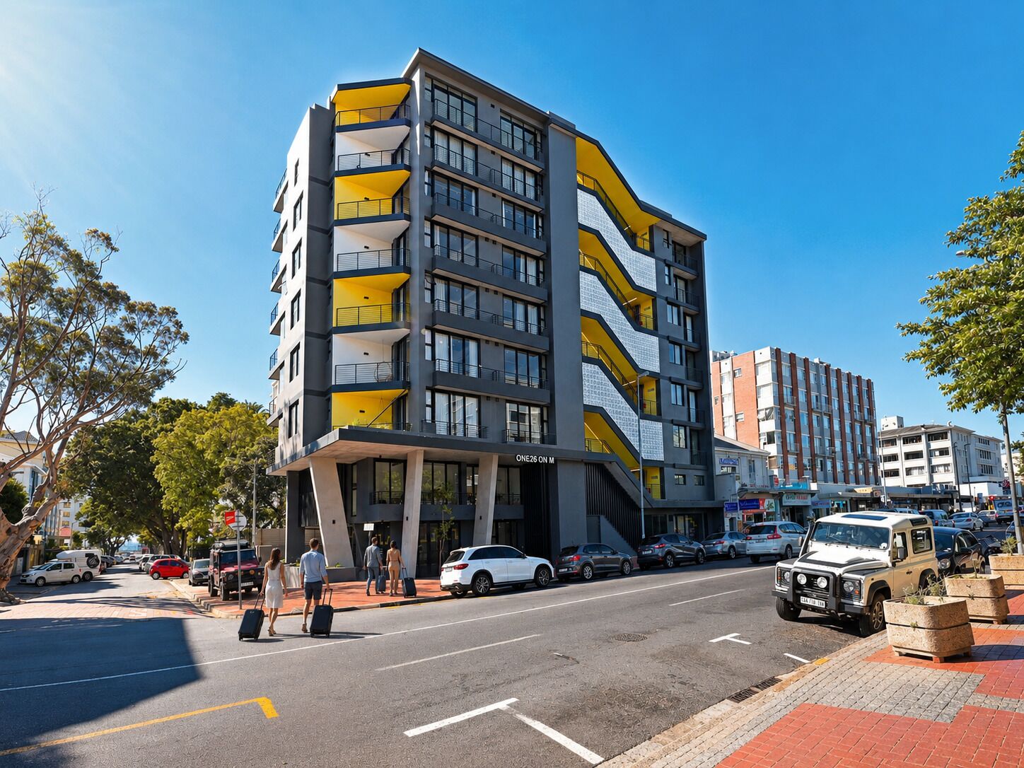 En byggnad med flera våningar och en modern arkitektonisk design, med balkonger och en framträdande entré.