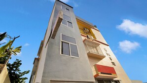 Un edificio a più piani con un design architettonico moderno, caratterizzato da un mix di balconi e finestre.