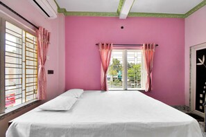 A room with a bed, pink walls, and a window with curtains. - iROOMZ Tilottama Guest House (Basirhat)