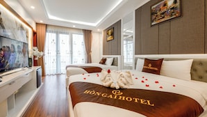 Hotellihuone, jossa on suuri sänky, televisio ja työpöytä.
