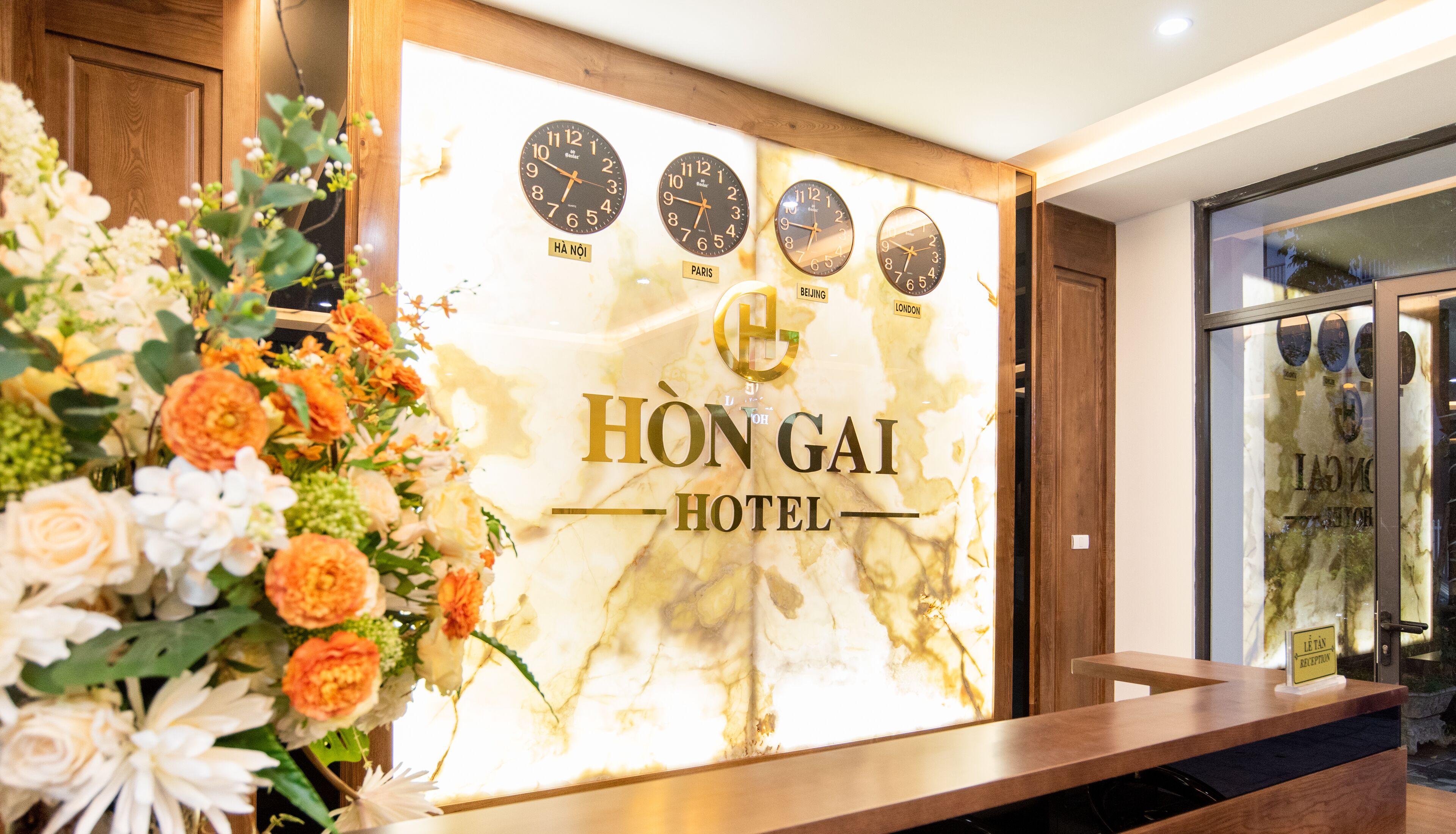 Una reception con un'esposizione floreale e orologi che mostrano l'ora di Parigi, Pechino e Londra.
