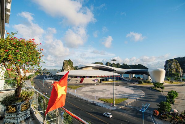 A modern building with a unique architectural design, a roundabout, and a flag. - Hon Gai Hotel (Ha Long)