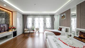 Una habitación de hotel con una cama, un escritorio, un televisor y una zona de comedor.