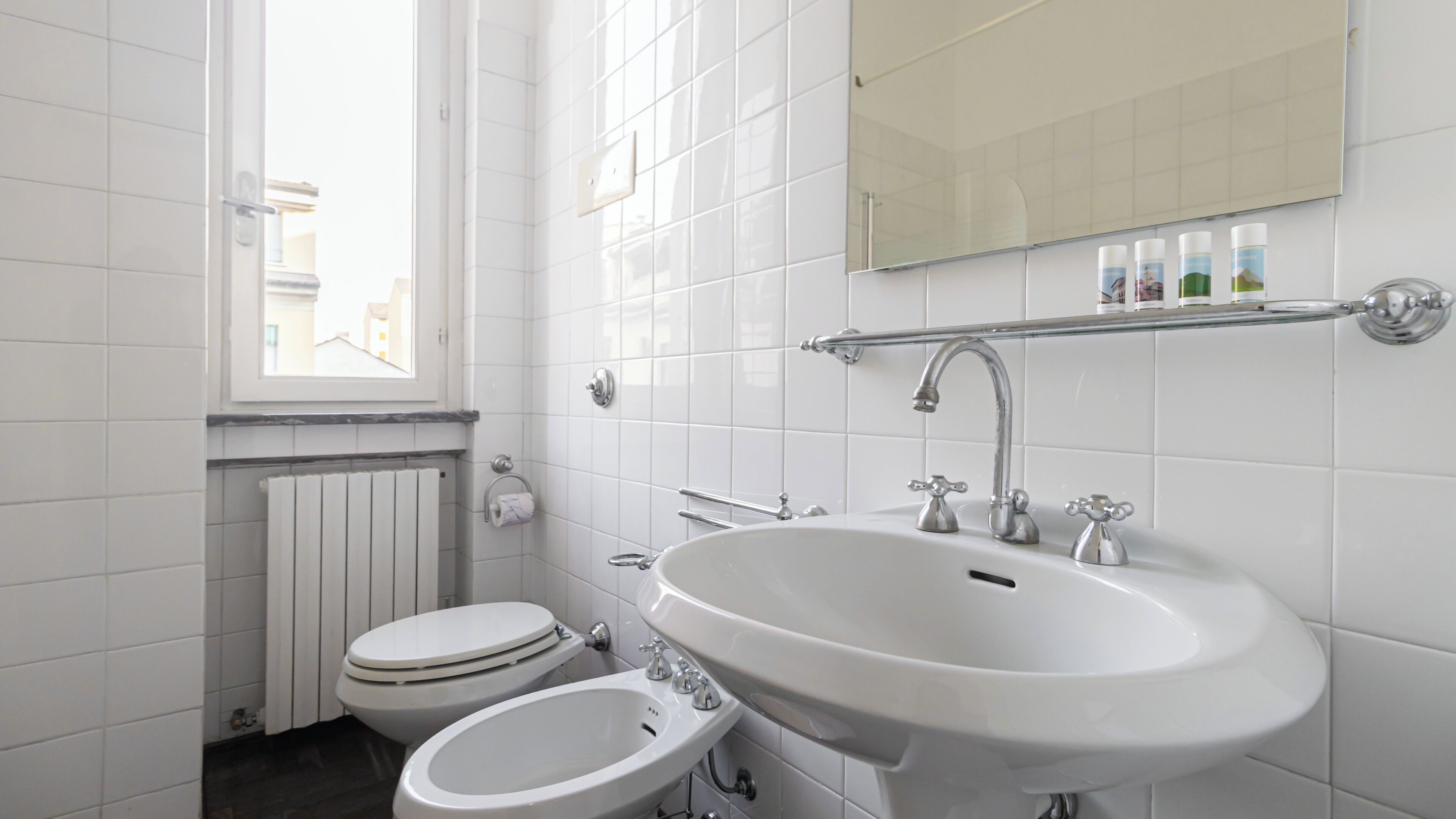 A modern bathroom with a toilet, bidet, and sink.