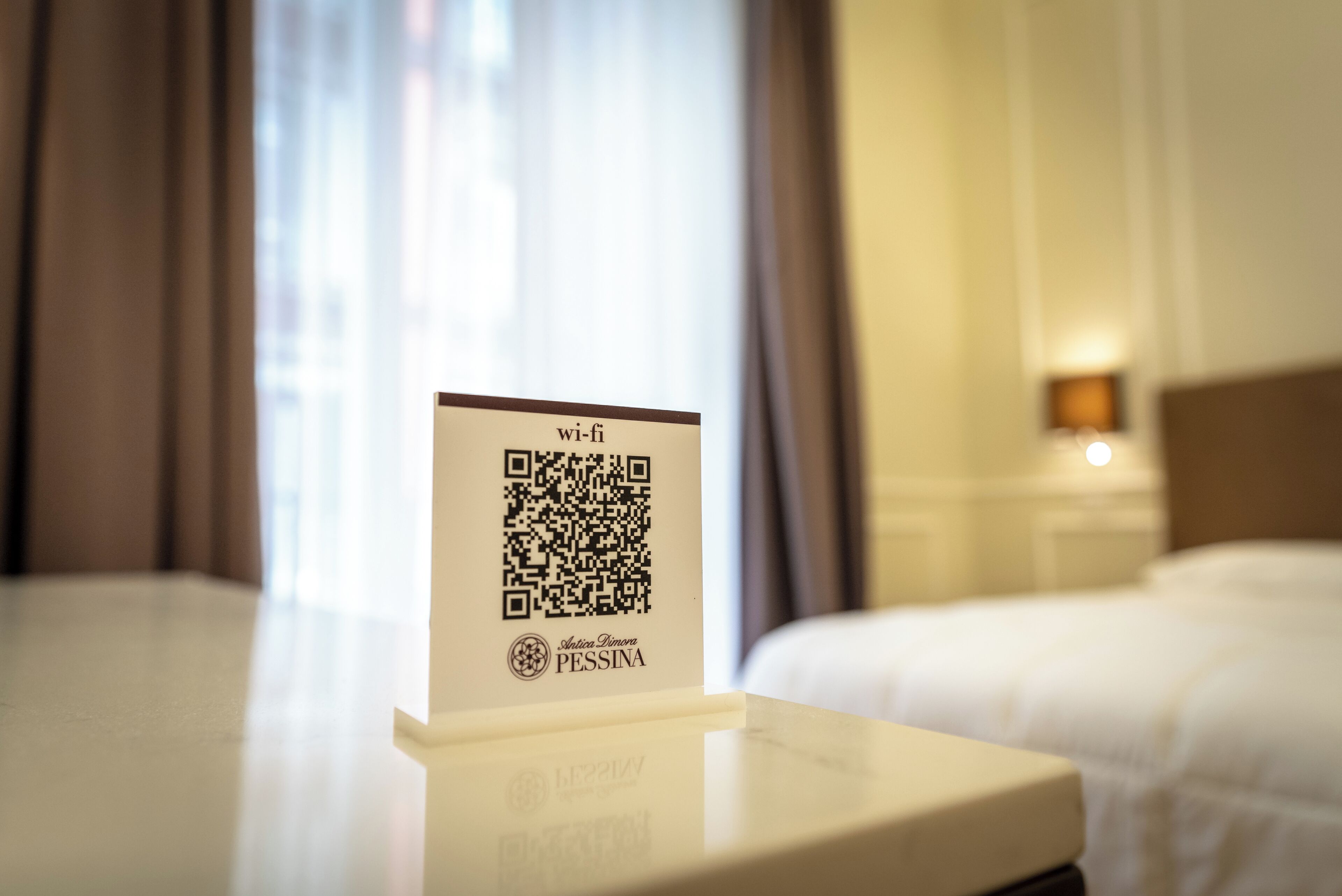 A QR code on a white stand in a hotel room, indicating Wi-Fi availability.
