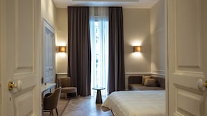 A hotel room with a bed, a desk, a chair, a small table, and a ceiling mural. - Antica Dimora Pessina (Naples)