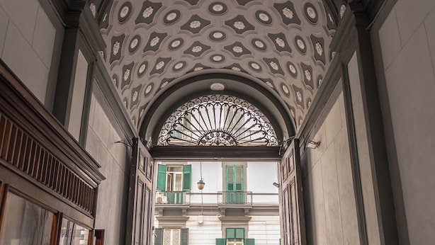 An ornate architectural entrance with a decorative ceiling and a wrought iron gate. - Antica Dimora Pessina (Naples)