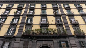 A multi-story building with balconies, a central entrance with an ornate arch, and a yellow facade. - Antica Dimora Pessina (Naples)
