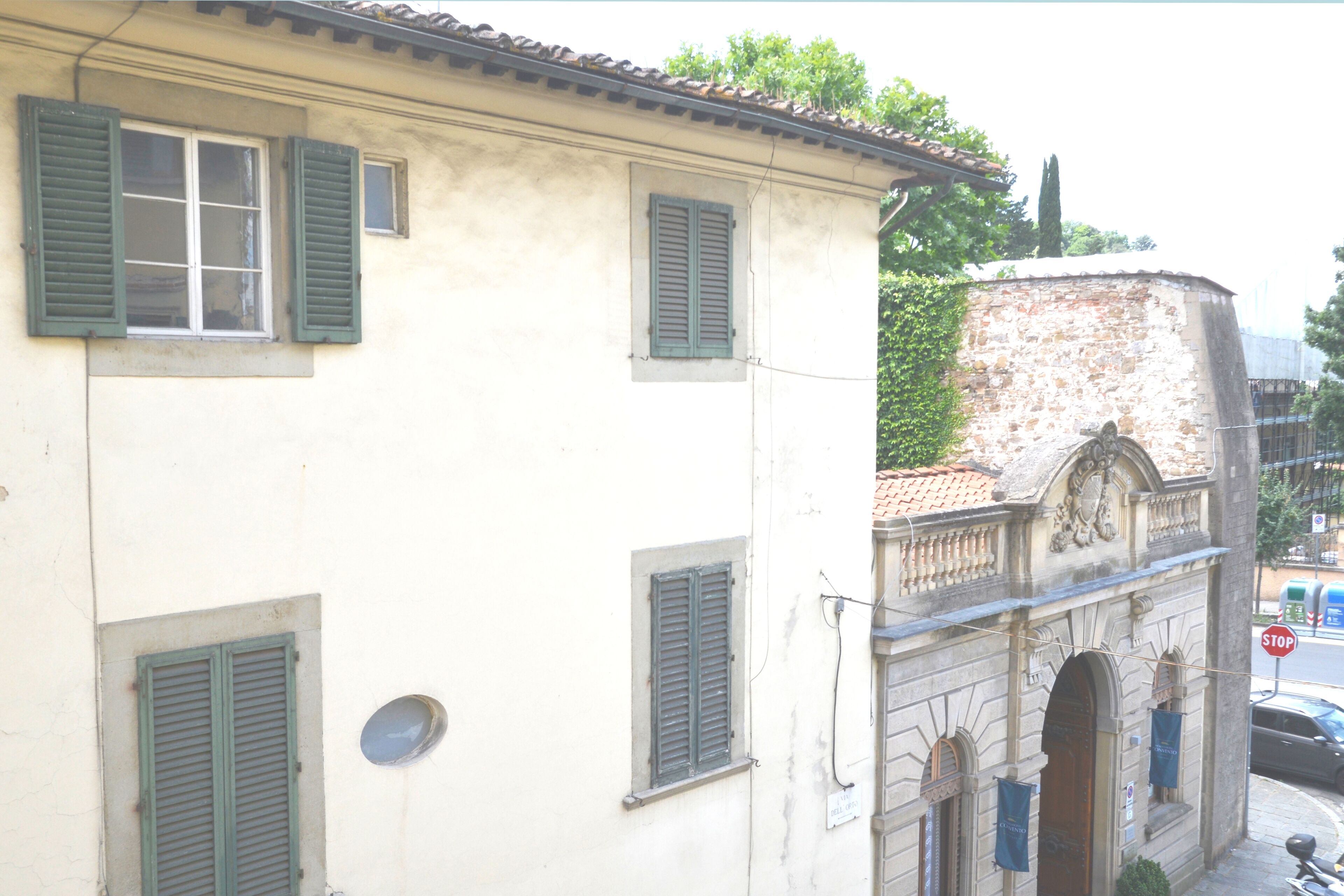 Un edificio con diverse finestre, un segnale di stop e una vista sulla strada.