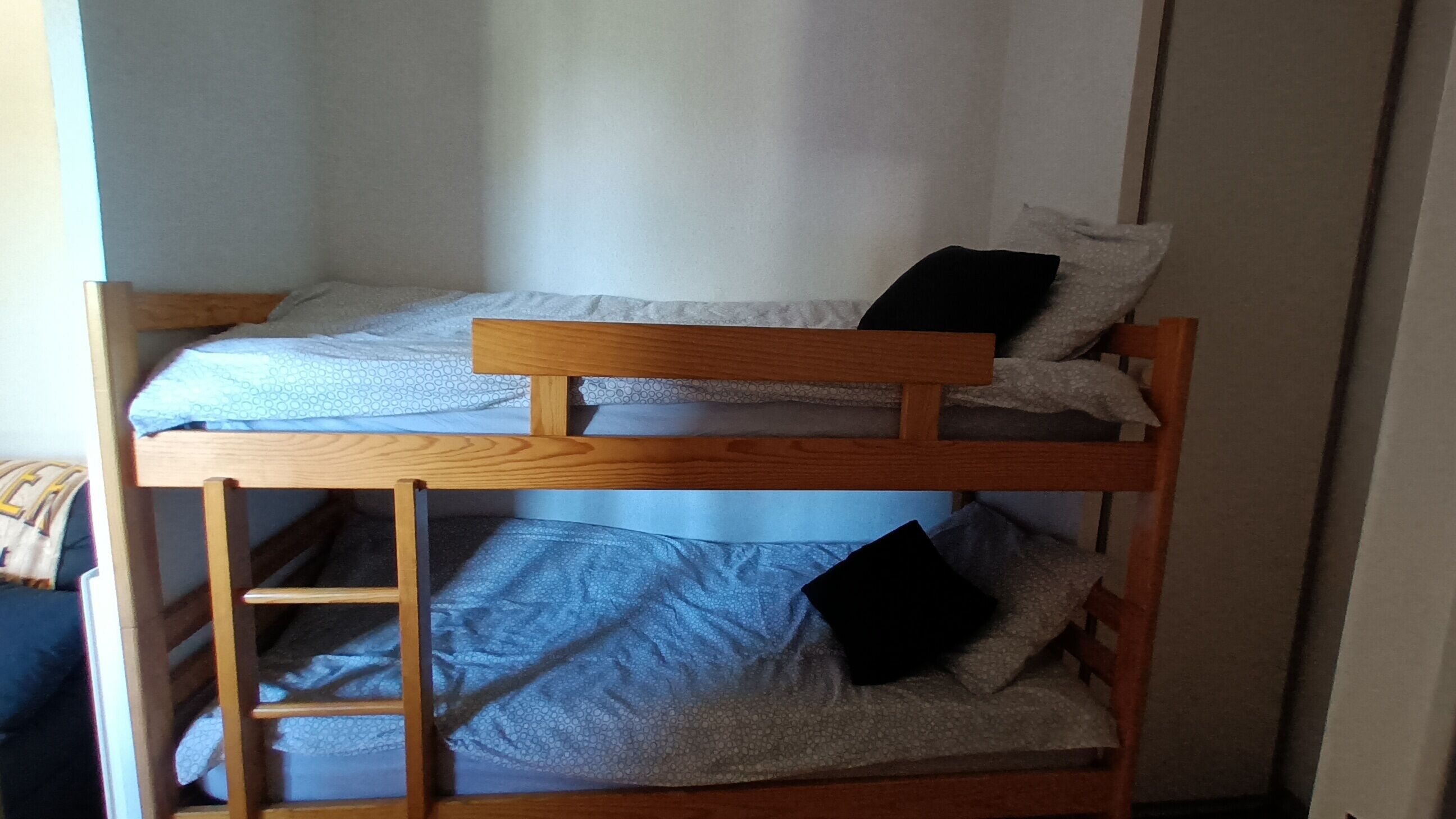 A bunk bed with a wooden frame and a ladder.