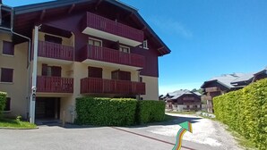 Un hotel de varios pisos con balcones y un estacionamiento.