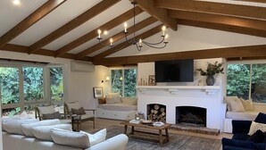 A spacious living room with a fireplace, large windows, and a cozy seating area. - Woolrich House - Woolrich House at Woolrich Estate (Olinda)