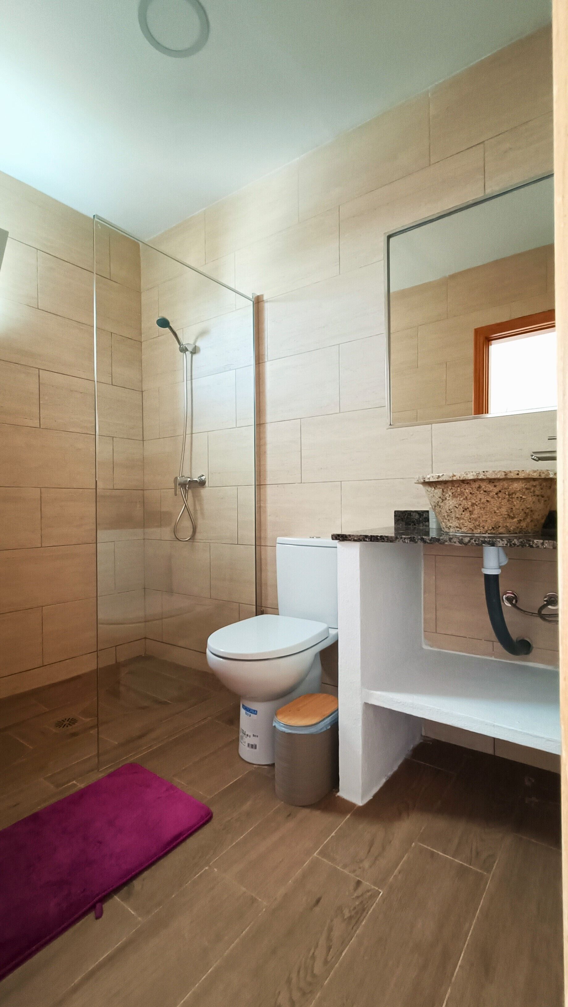 Un baño moderno con ducha, inodoro y lavamanos.
