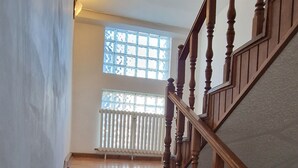 Una scala in legno con corrimano che porta a un pianerottolo.