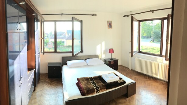 Una camera da letto con un letto, un comodino, una cassettiera e una finestra vista esterna.