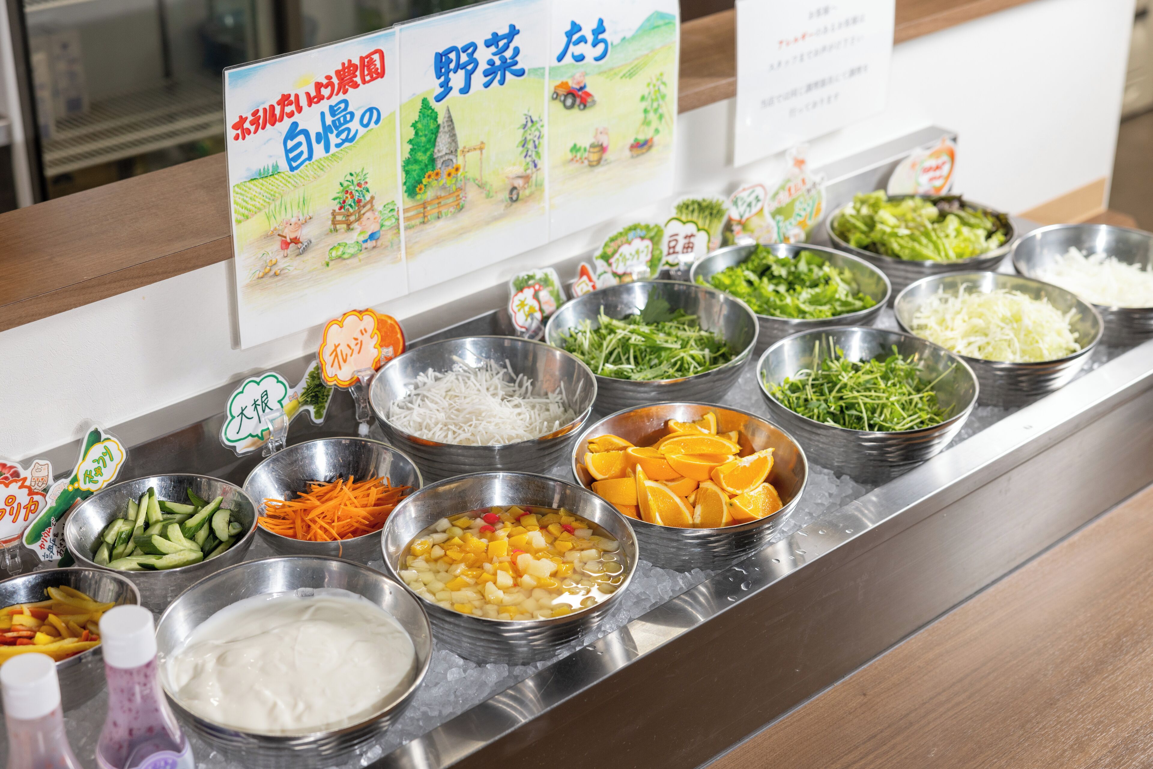 A buffet with various food options including vegetables, fruits, and noodles.