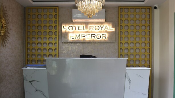 A reception desk with a marble top, a chandelier above, and a sign that reads "HOTEL ROYAL EMPEROR" on the wall. - Hotel Royal Emperor (Kathmandu)