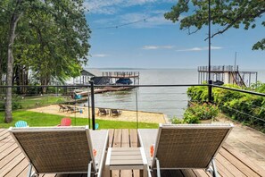 A deck with two chairs facing a dock and water. - Dreamy Lake Cottage, Beach, Dock, Deep Water, Boat Ramp (Mabank)