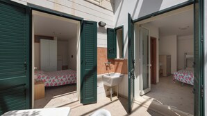 Una habitación con cama, lavamanos y espejo.