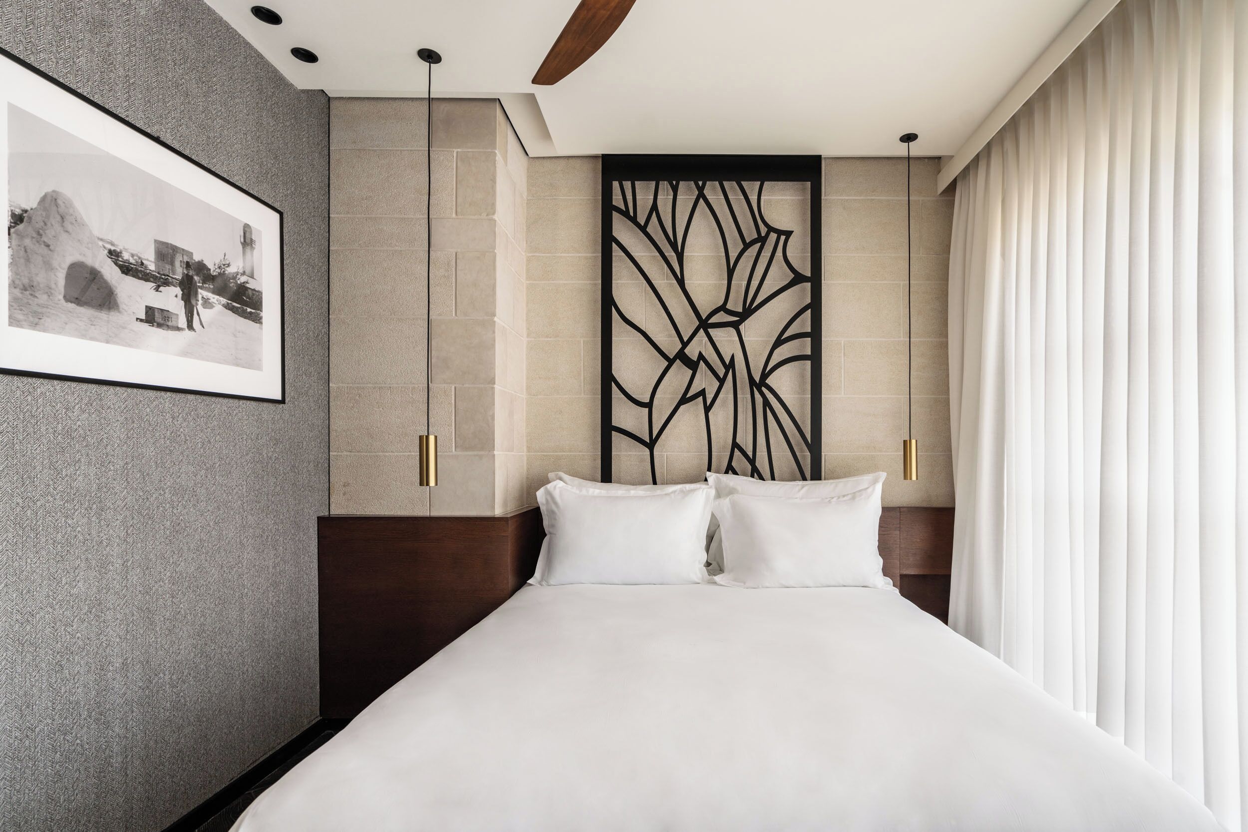 Una habitación de hotel moderna con una cama grande, una fotografía enmarcada en la pared y un panel decorativo.