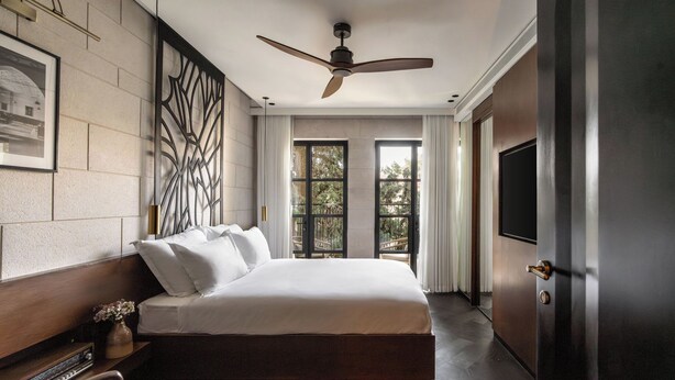 Un dormitorio moderno con una cama grande, un ventilador de techo y vistas a través de la ventana.