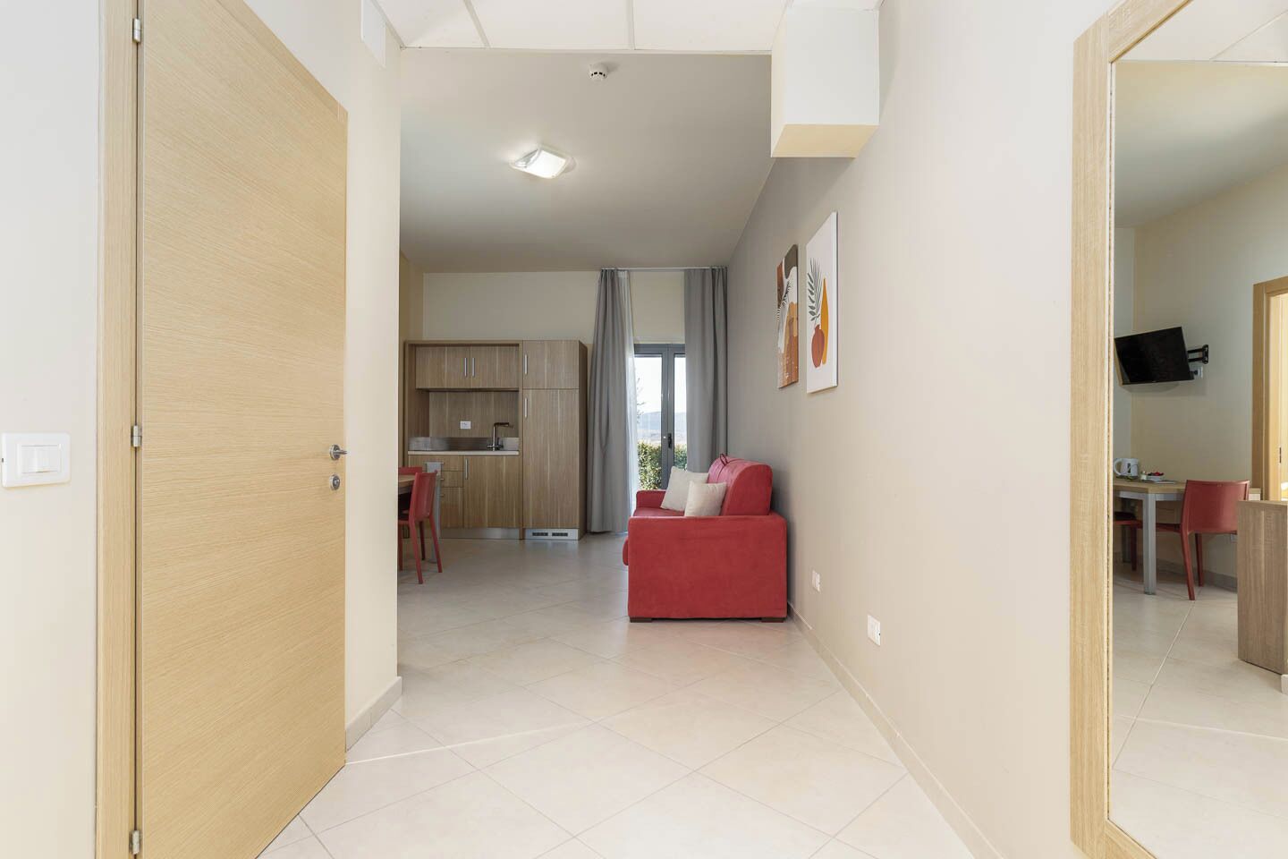 A modern apartment with a kitchen, dining area, and living room.