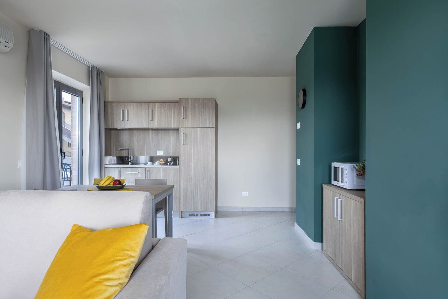 A modern apartment with a living area, kitchenette, and a dining space.