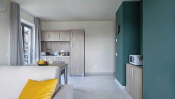 A modern apartment with a living area, kitchenette, and a dining space.