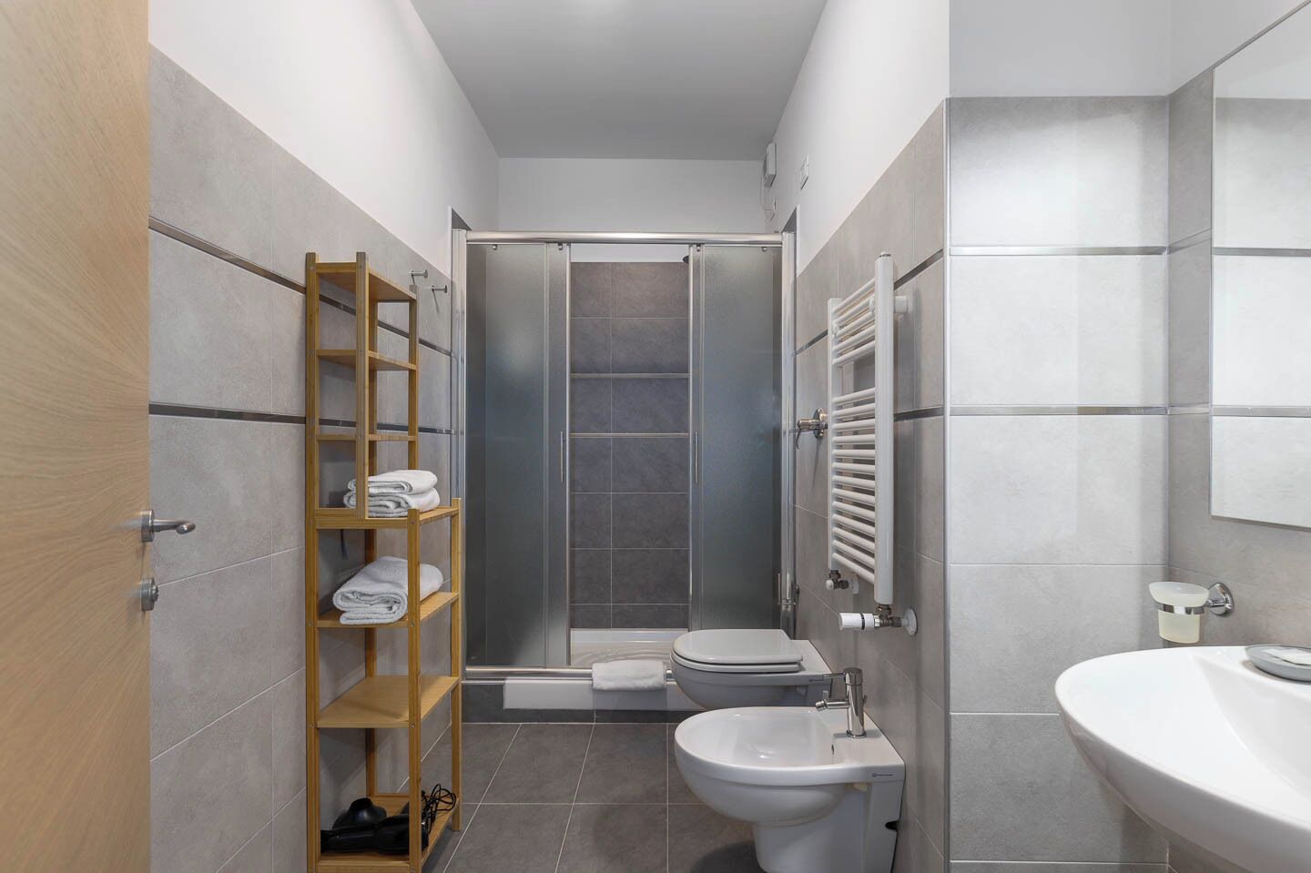 Een kleine badkamer met een douche, toilet en wastafel.