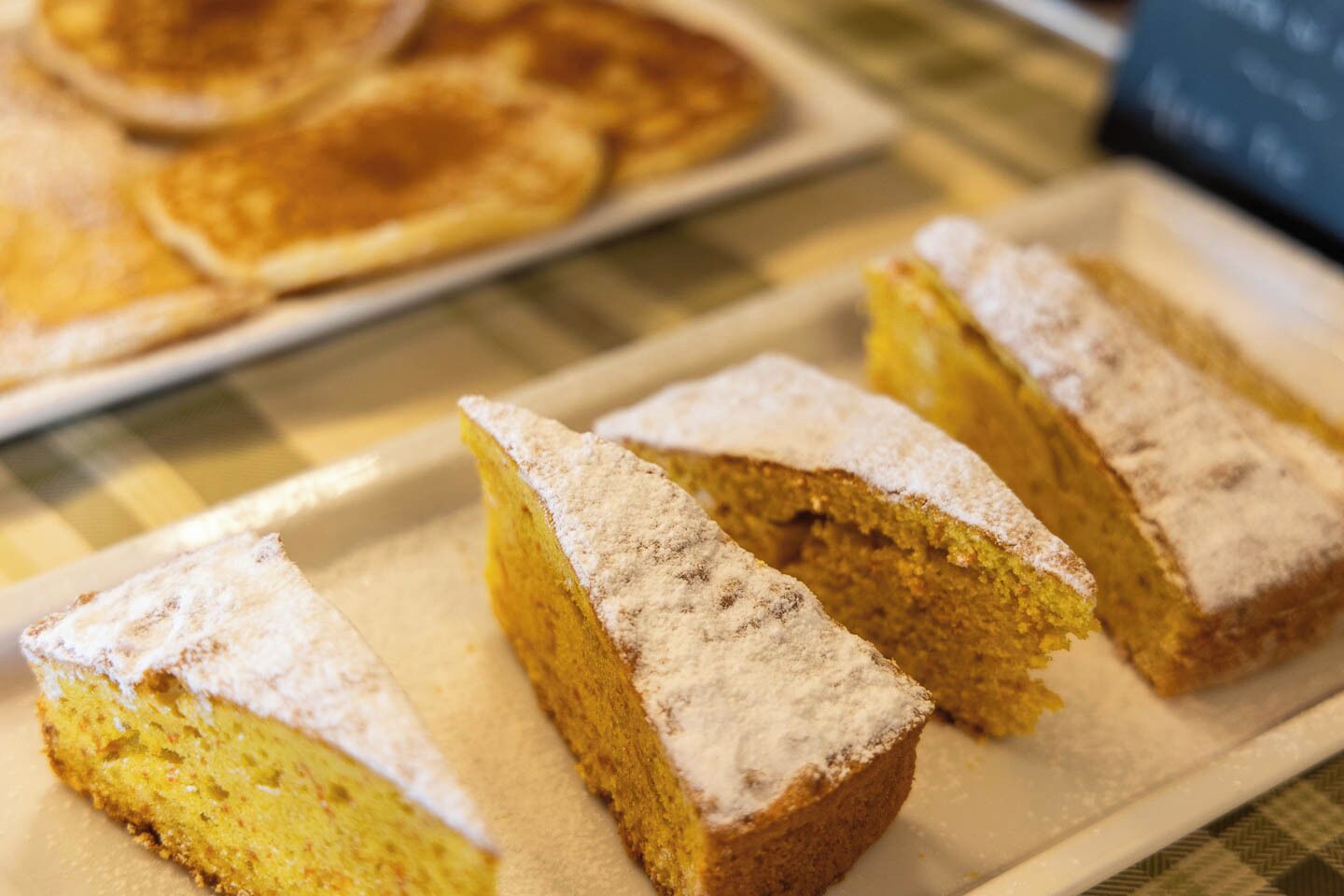 Slices of cake with powdered sugar on a plate.