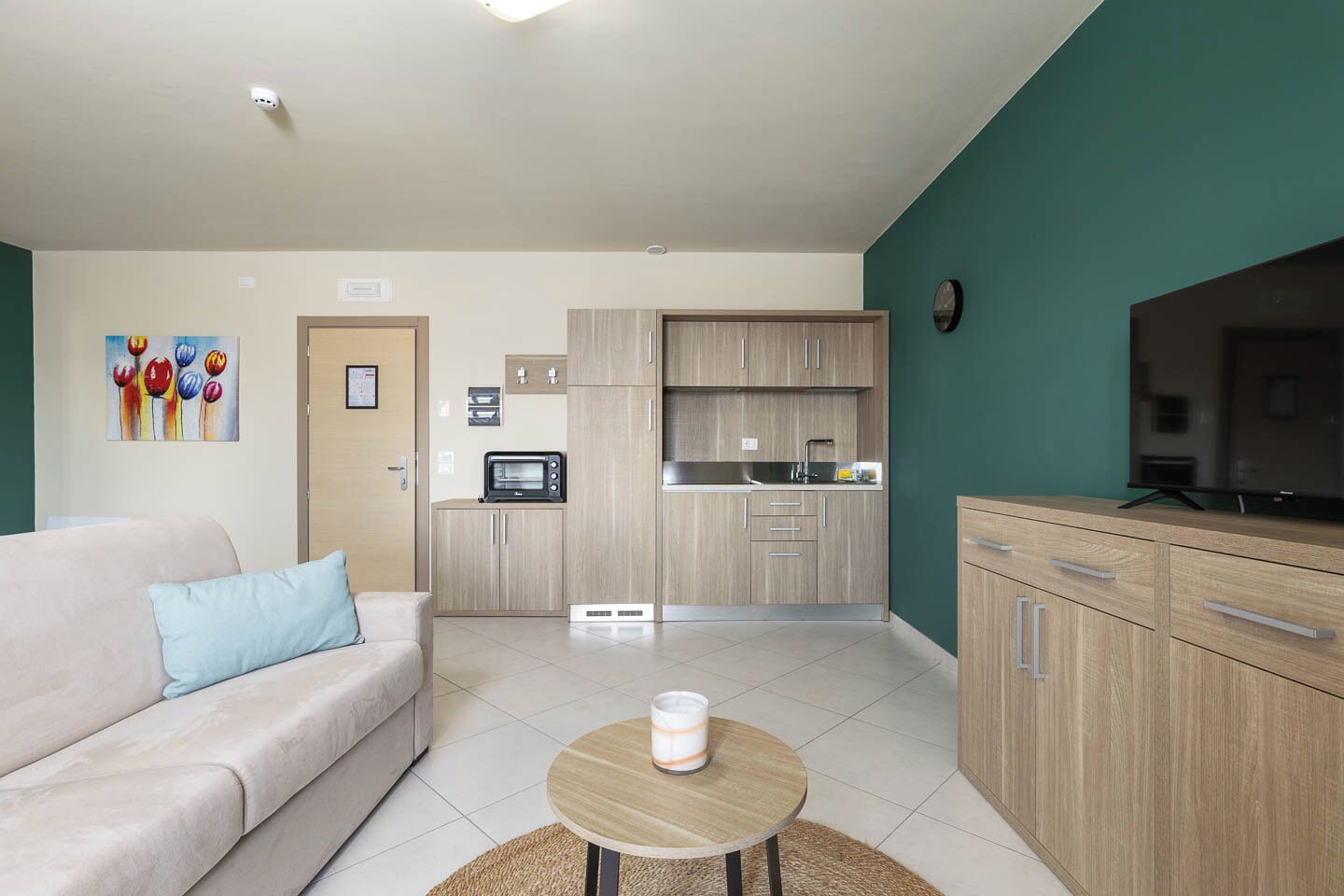 Un apartamento moderno con sala de estar, kitchenette y zona de TV.