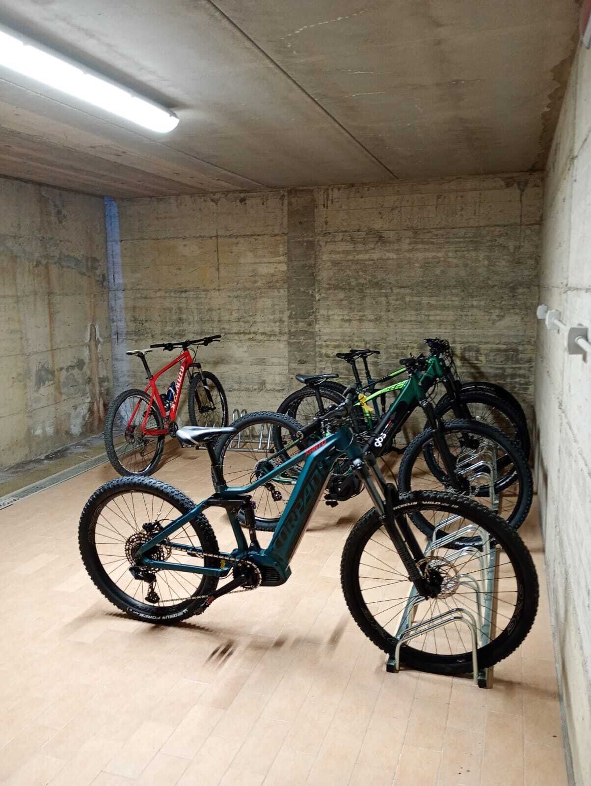 Een ruime binnenruimte met fietsen langs de muren geparkeerd.