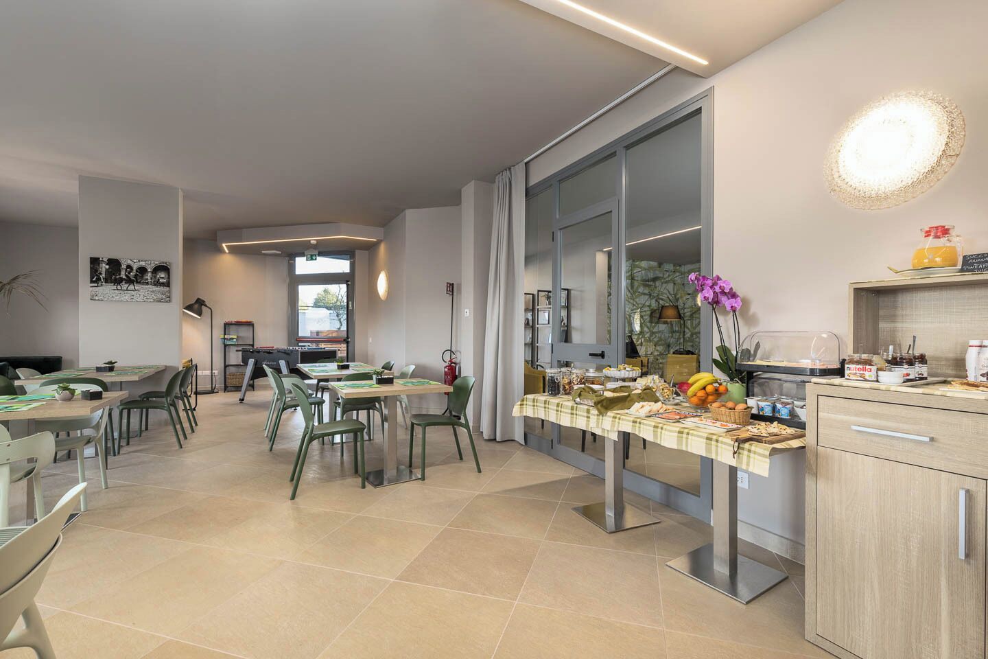 Een moderne eetruimte met een lange tafel, stoelen en een buffetopstelling.