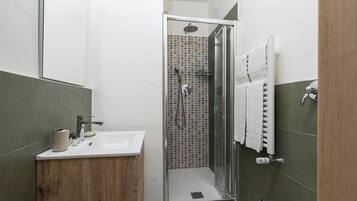 Un baño moderno con ducha, lavabo e inodoro.