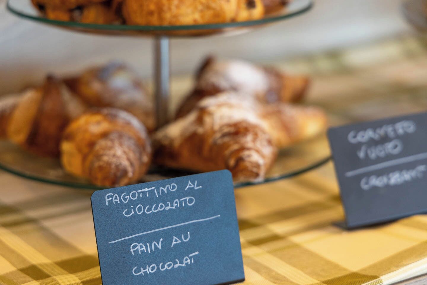 Una presentación de pasteles con etiquetas que indican sabores como chocolate y café.