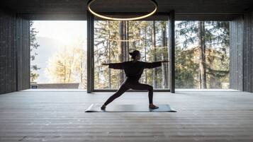 Une pièce spacieuse avec une grande fenêtre, un plancher en bois et un luminaire circulaire au plafond.