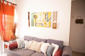 Relax in this stylish living room with a comfortable sofa, abstract art, and a window with a view.