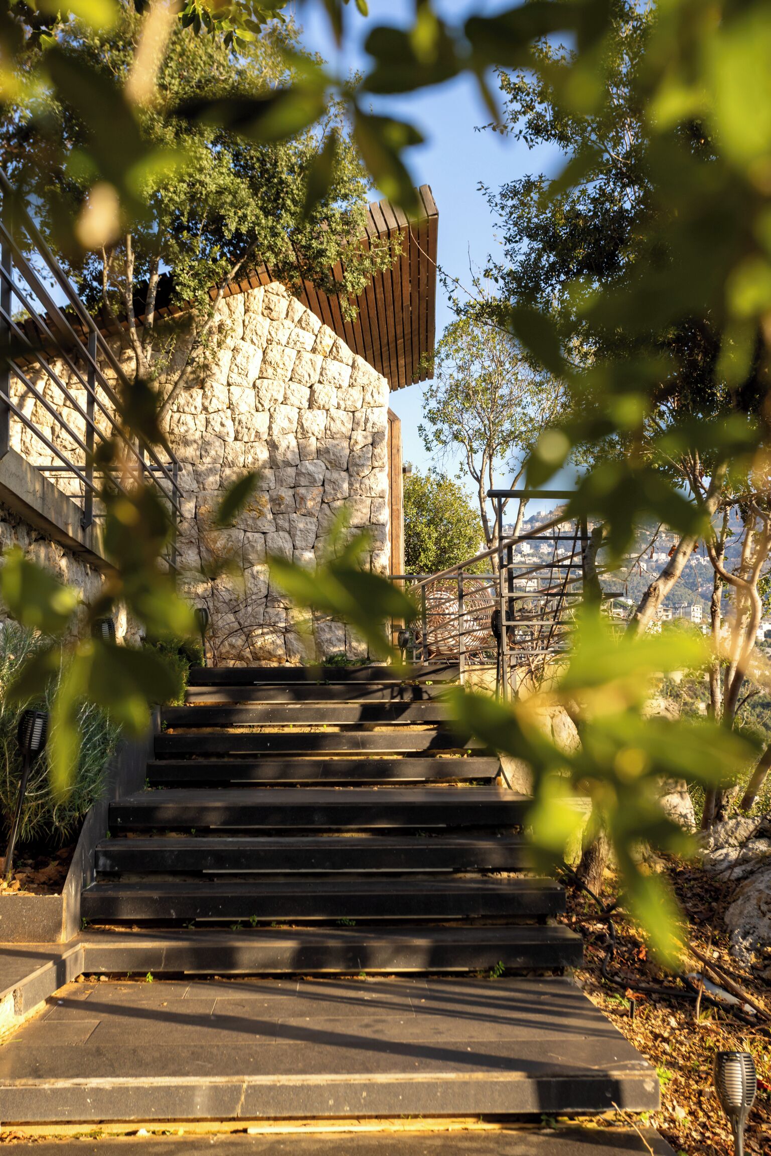 A set of stone steps leading up to a wooden structure with a stone wall.